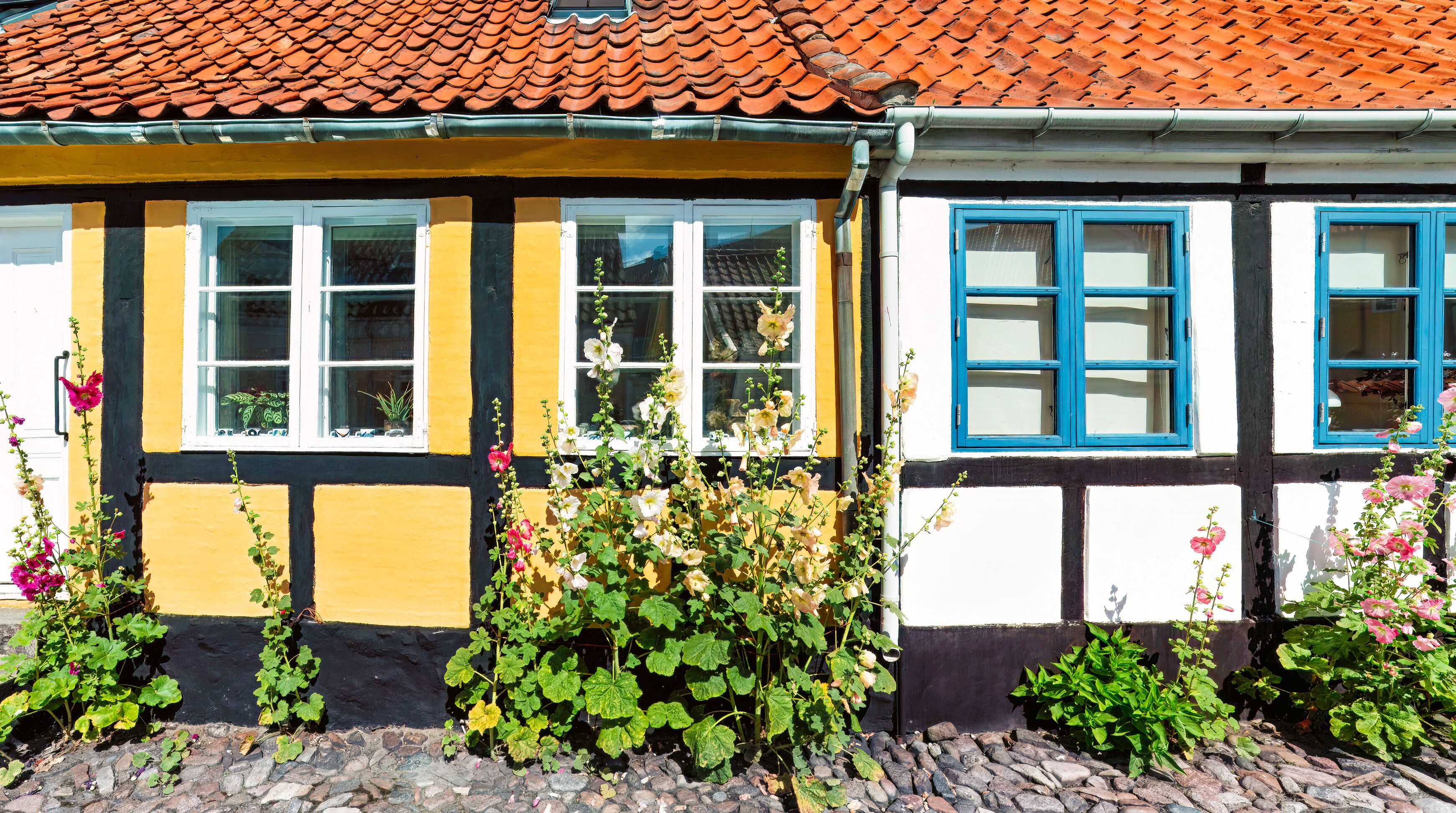Painted like memory half timbered houses of Ronne,  bloom at the base with hollyhocks. Summer slowly  rhythm in pale blue and honey tones.