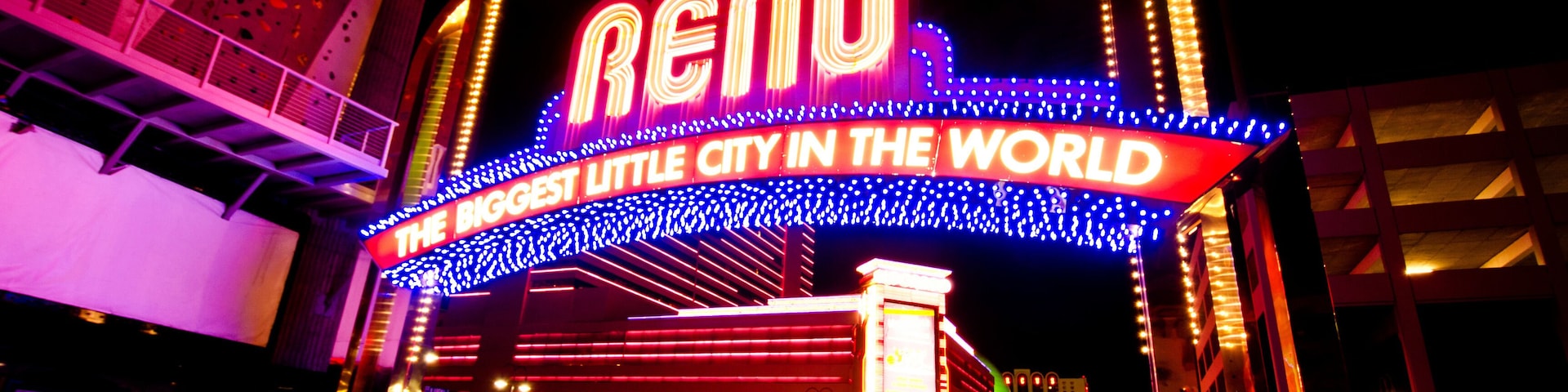 El cartel de Reno con la palabra 'Reno' e 'La ciudad más pequeña y grandiosa del mundo' iluminado en la noche.
