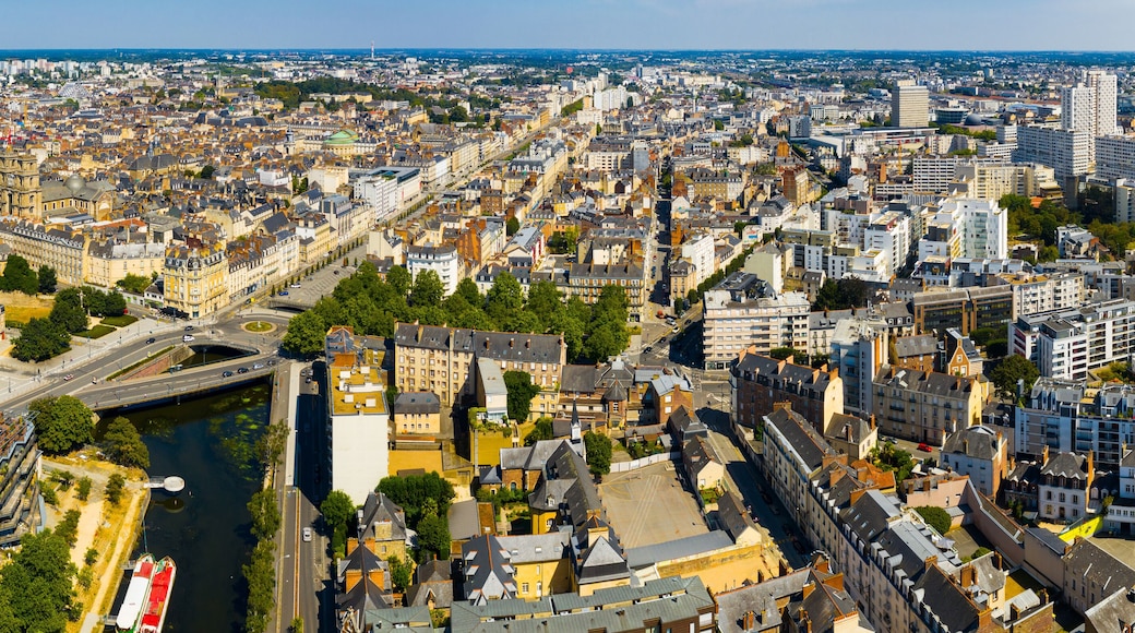 Une vue aérienne d’une ville densément peuplée, traversée par une rivière et entourée de bâtiments historiques et d’une architecture moderne.