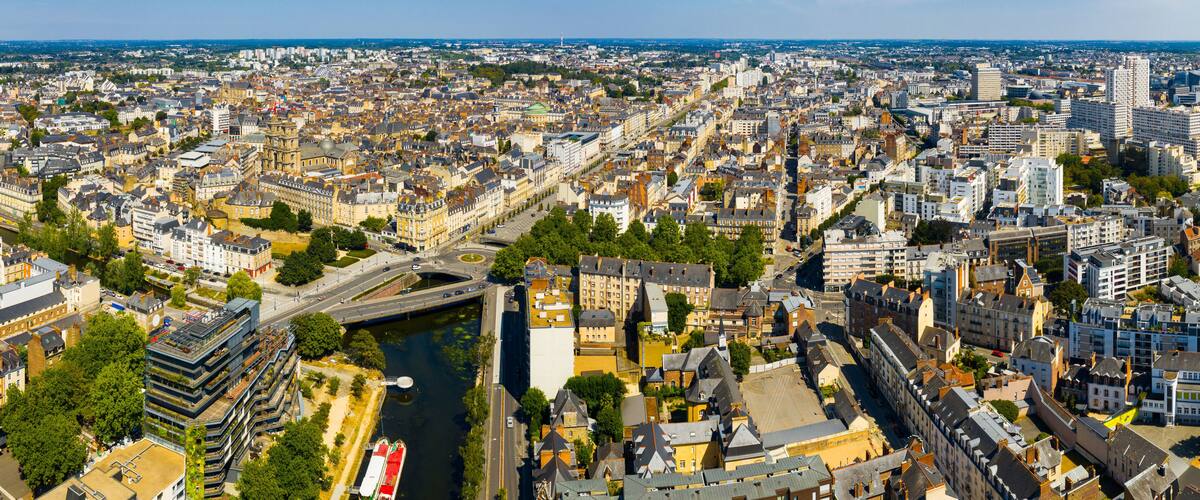 An aerial view of a densely populated city with a river running through it, surrounded by historic buildings and modern architecture.