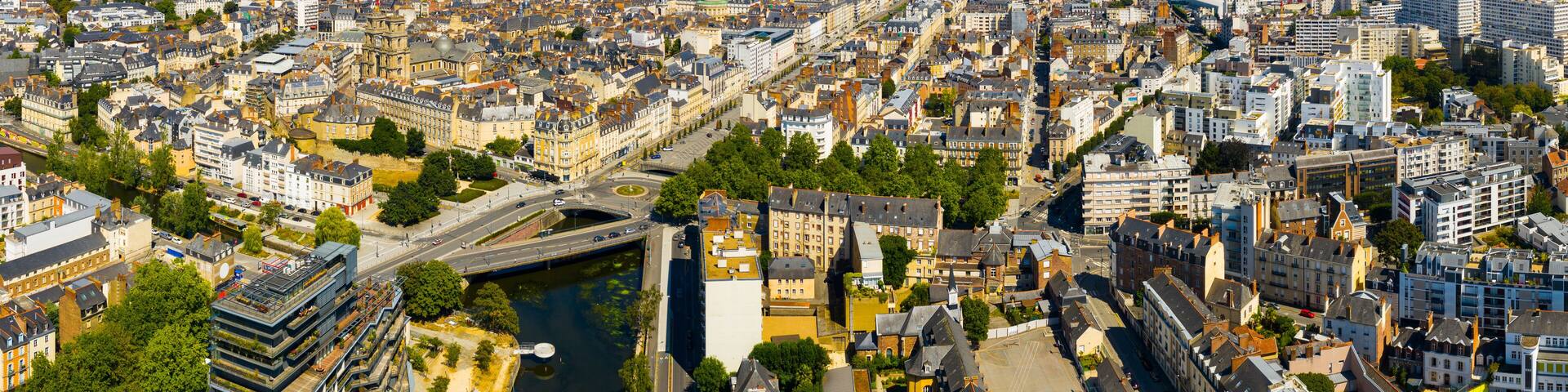 An aerial view of a densely populated city with a river running through it, surrounded by historic buildings and modern architecture.