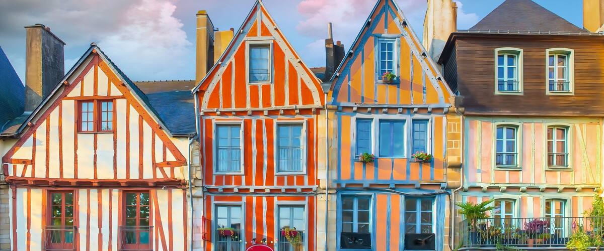 A row of colorful half-timbered houses with steep roofs and chimneys.