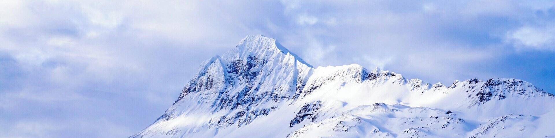 Un pico nevado de montaña bajo un cielo despejado.