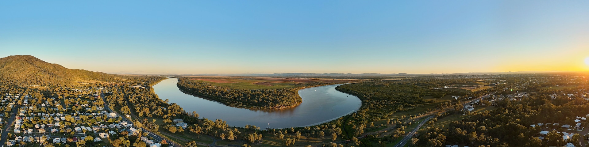 A river winding through a town surrounded by hills.