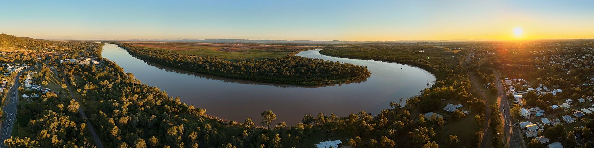 A river winding through a forested area with a small town on one side.