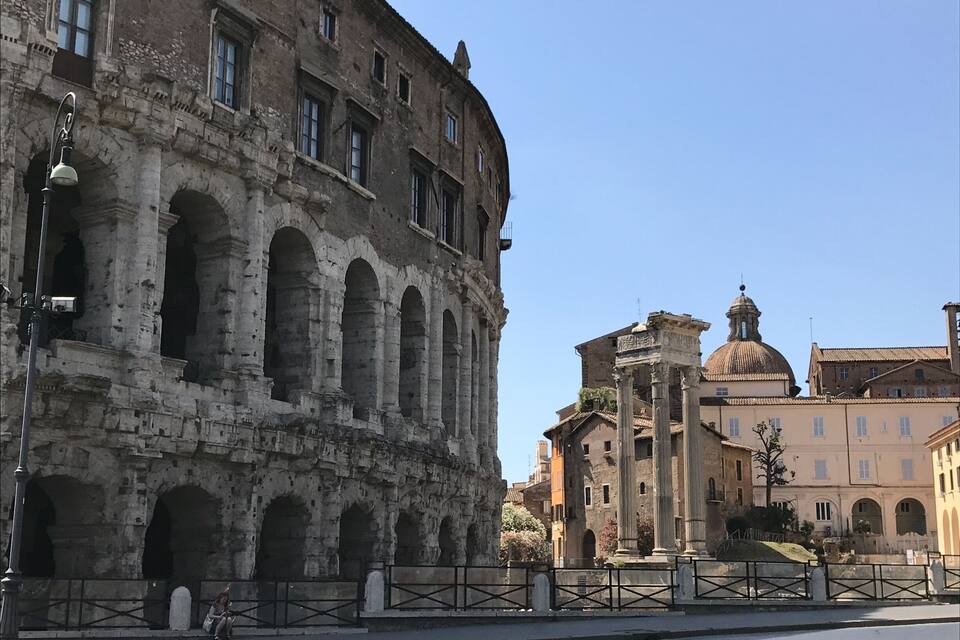 El Coliseu amb una cúpula i un edifici modern al fons.