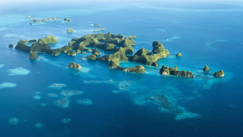 An aerial view of a cluster of islands with clear blue waters and coral reefs.