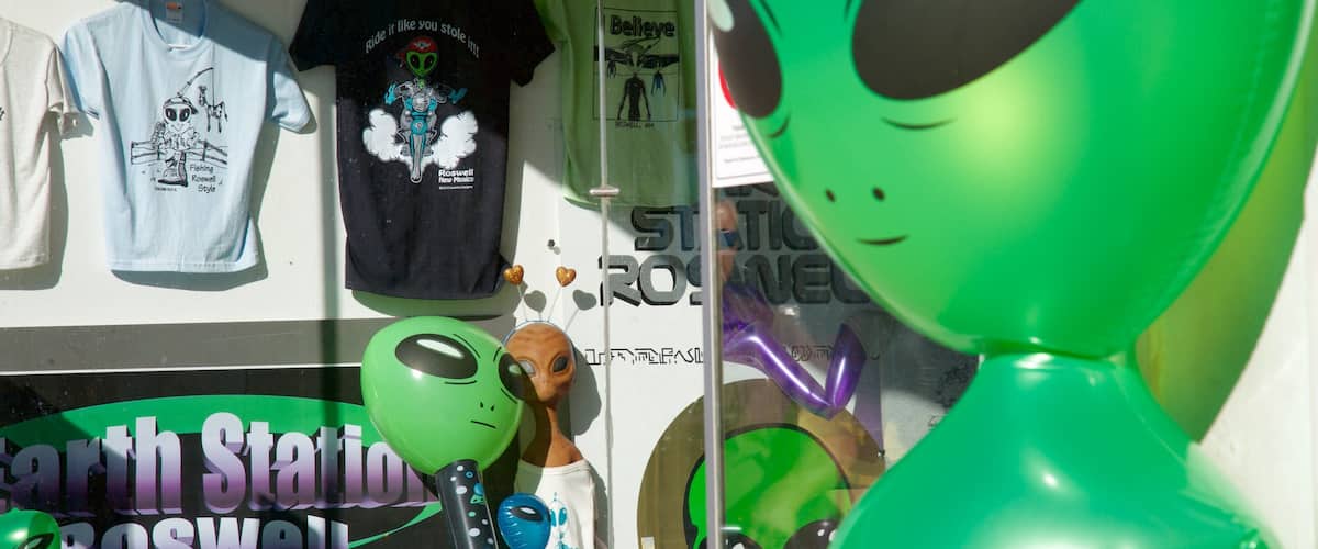 A store window with various merchandise including t-shirts and alien figures.