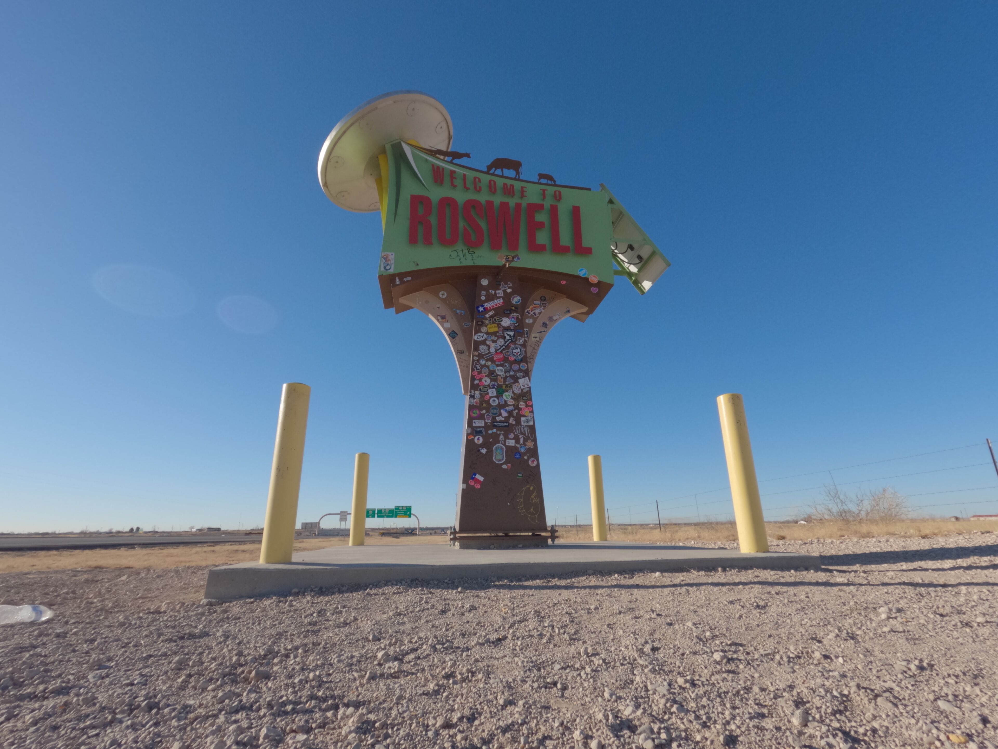 A welcome sign to Roswell with a clear blue sky in the background.