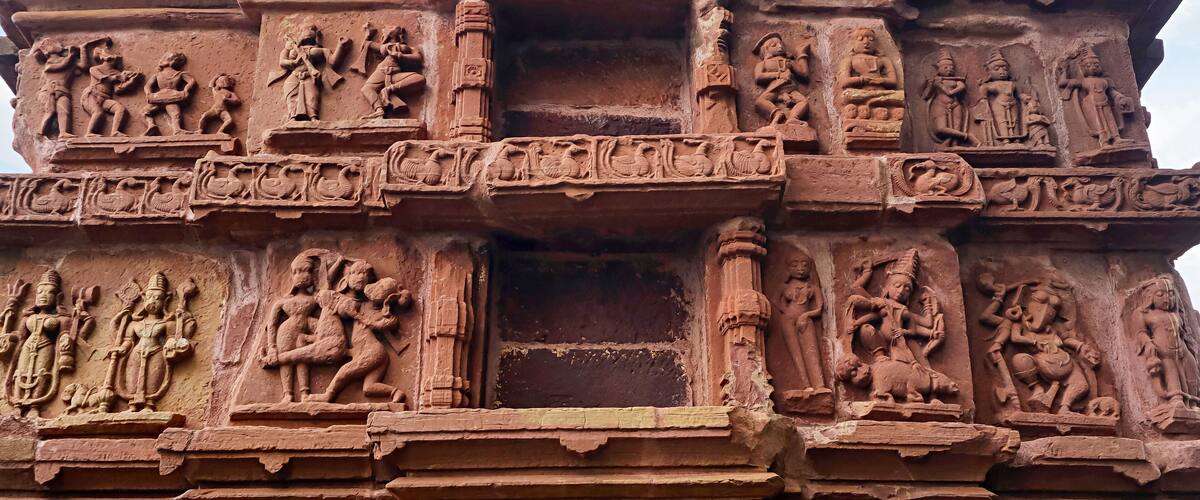 A detailed stone carving with multiple figures and scenes, likely part of an ancient temple or monument.