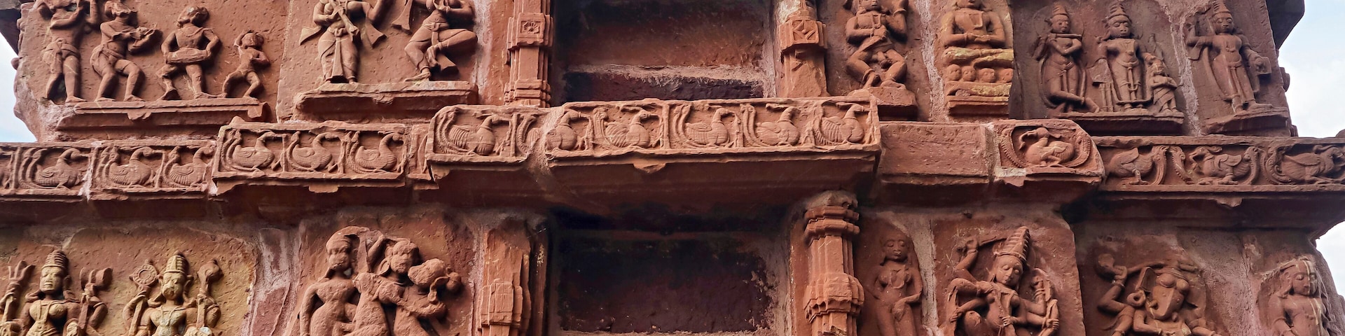 A detailed stone carving with multiple figures and scenes, likely part of an ancient temple or monument.