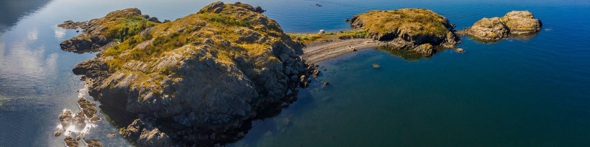 Boating in the San Juan Islands Of Puget Sound and Washington State. Aerial view of a small skiff on the beach at Lummi Rocks off the southwest corner Of Lummi Island in the Pacific Northwest.