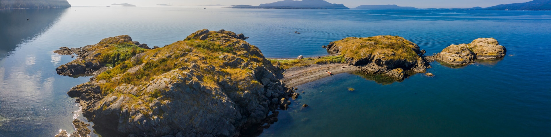Boating in the San Juan Islands Of Puget Sound and Washington State. Aerial view of a small skiff on the beach at Lummi Rocks off the southwest corner Of Lummi Island in the Pacific Northwest.