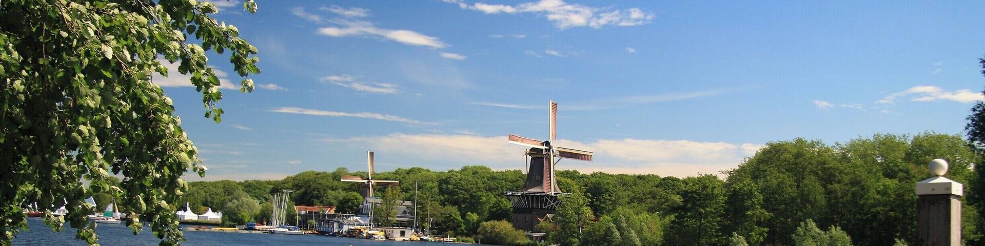 A river with windmills and a wooden dock.