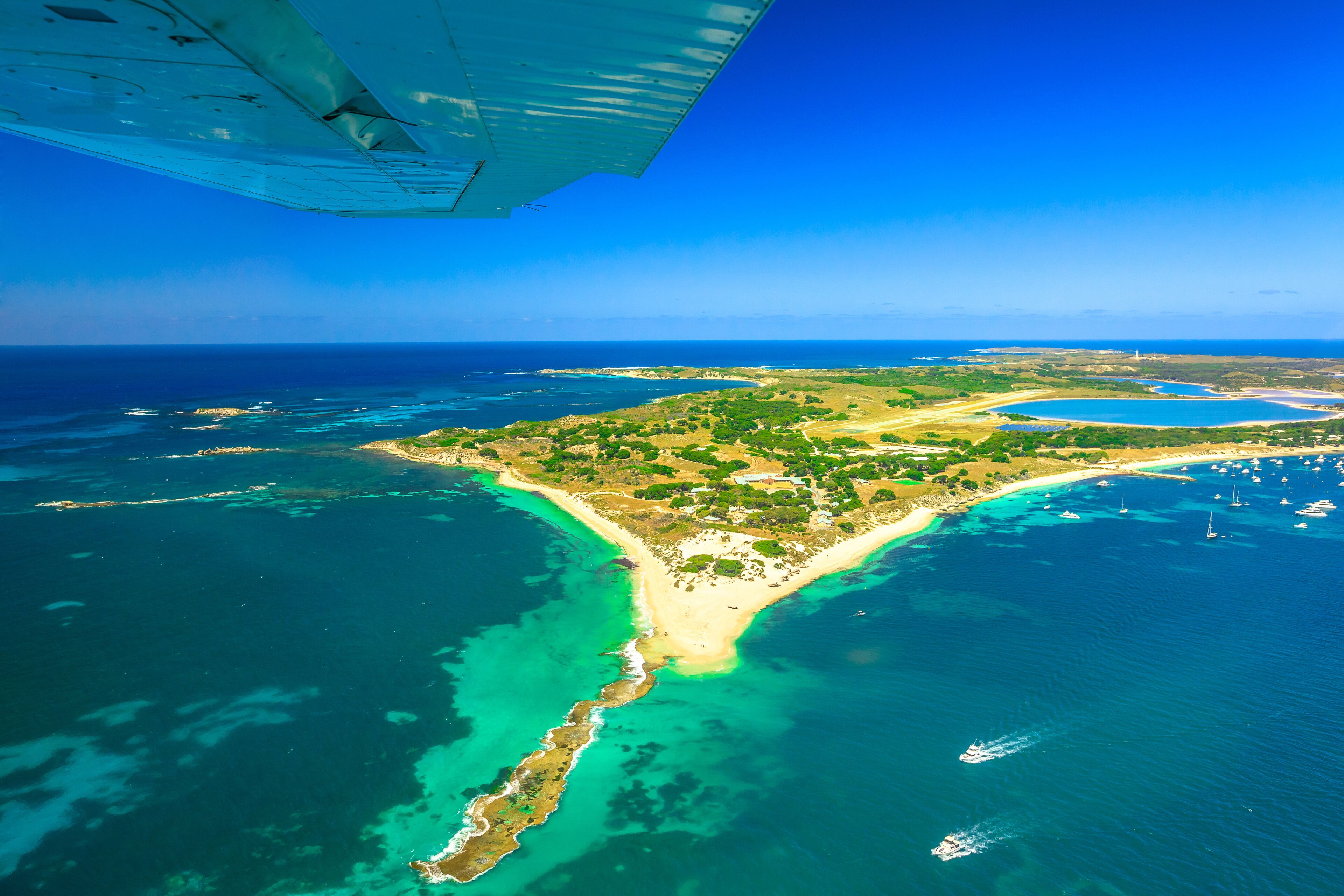 Aerial view of Rottnest Island in Australia. Scenic flight with wing of plane over famous tourist destination of Western Australia. Rottnest Island is located near Fremantle and Perth.