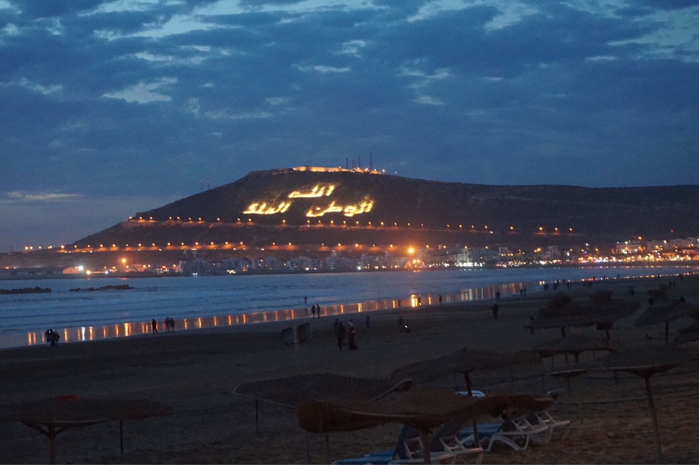 Agadir, a city along Morocco’s southern Atlantic coast, in the foothills of the Anti-Atlas Mountains, is the capital of Agadir-Ida Ou Tanane province. A resort destination, it's known for its golf courses, wide crescent beach and seaside promenade lined with cafes, restaurants and bars. Agadir's hilltop kasbah was destroyed in a 1960 earthquake, but its original old wall remains standing.
The arabic writings on the kasbah is a reminder to people which means God, Nation and King.