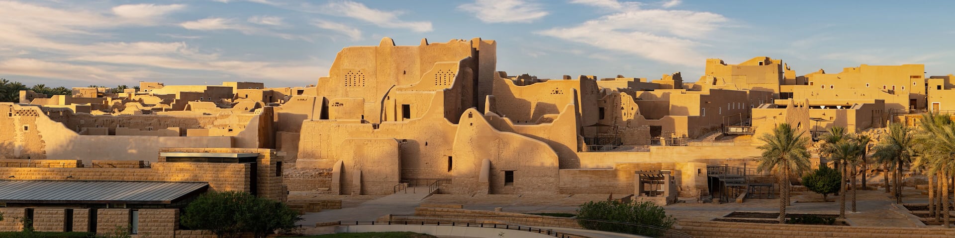 A historic walled city with traditional architecture and palm trees.