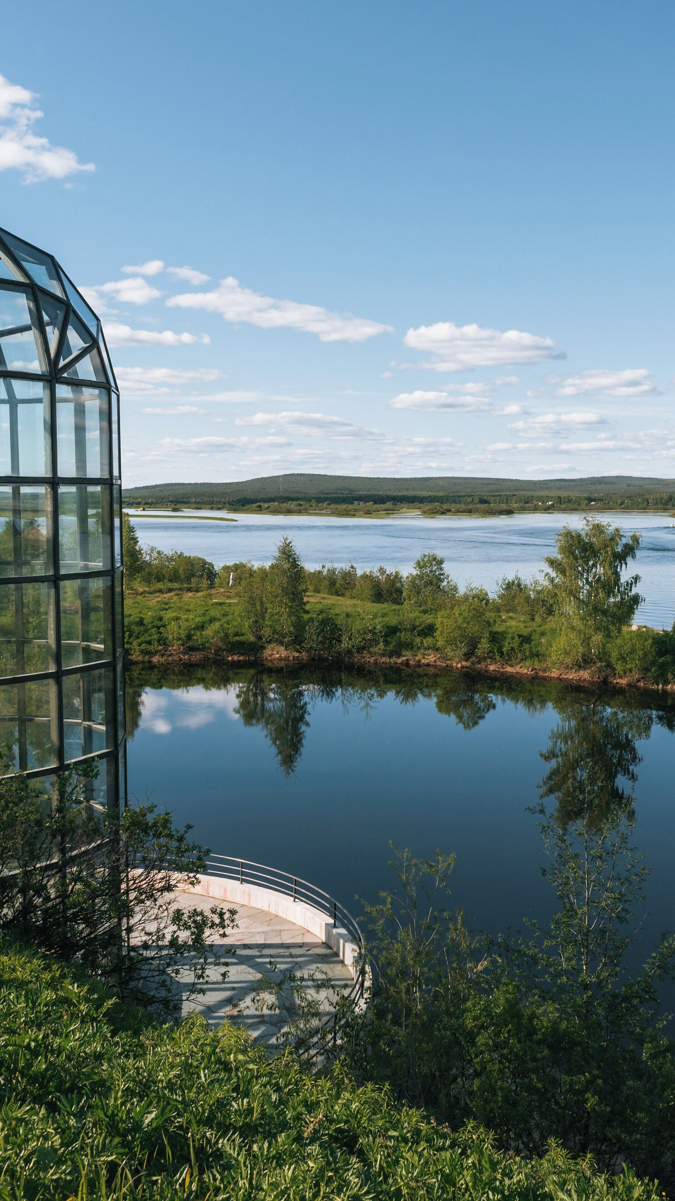 Explore the beauty of Arktikum in Rovaniemi, Lapland, Finland with its stunning architecture and tranquil riverside views under a clear blue sky