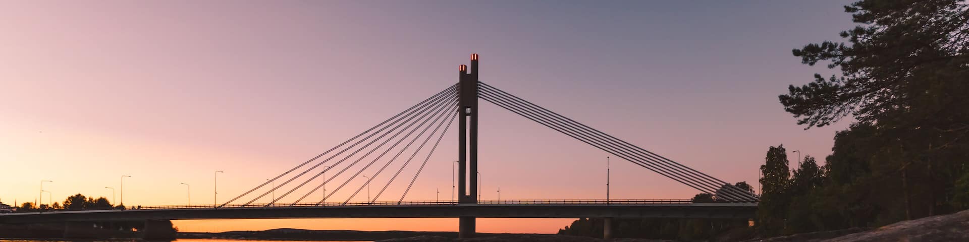 Lumberjack’s Candle Bridge in Rovaniemi Finland reflecting on Kemijoki River at sunset
