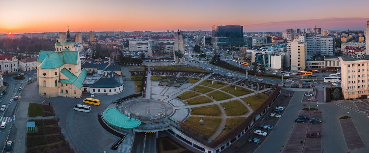 Un paisaje urbano con una iglesia destacada, una glorieta y edificios modernos.