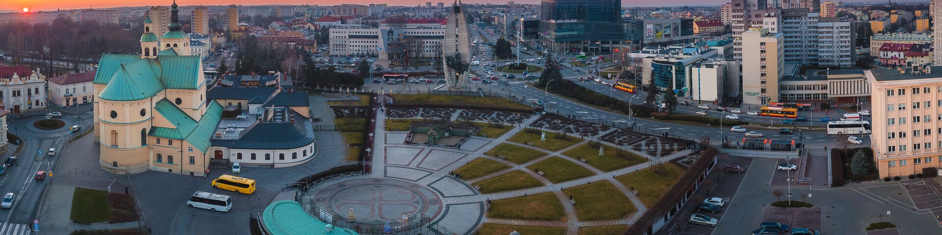 Un paisaje urbano con una iglesia destacada, una glorieta y edificios modernos.
