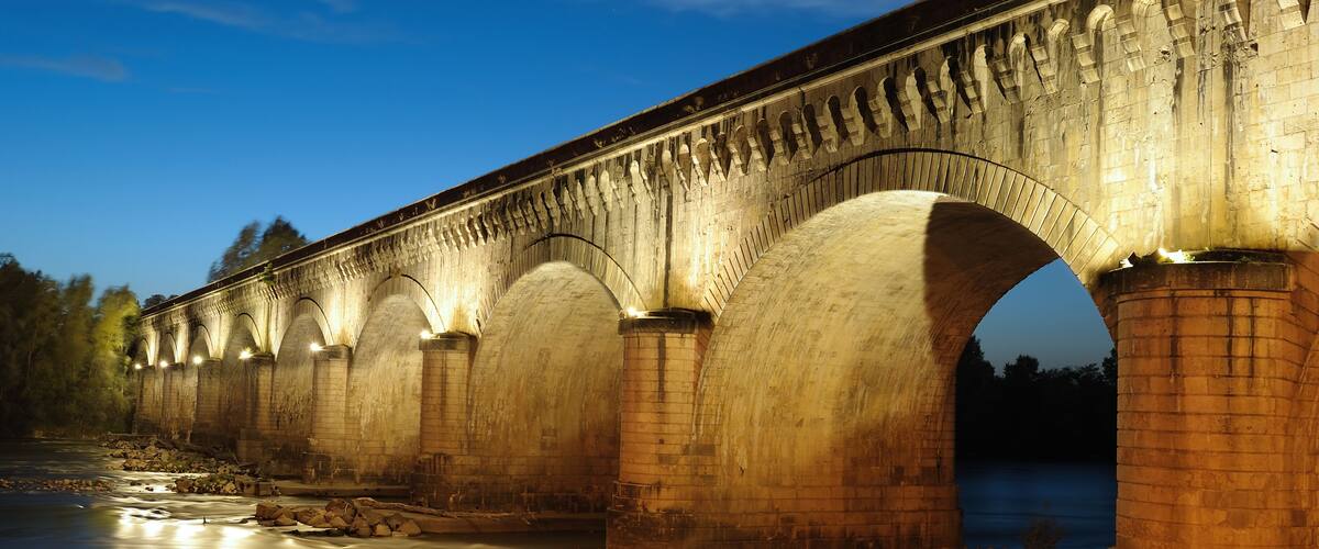 Un ponte di pietra su un fiume al crepuscolo.