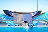 Un spectacle de dauphins dans un parc aquatique, avec un grand écran numérique en arrière-plan et un dauphin sautant hors de l’eau.