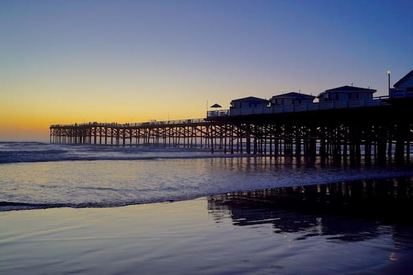 A pier extending into the ocean with buildings on the right side.
