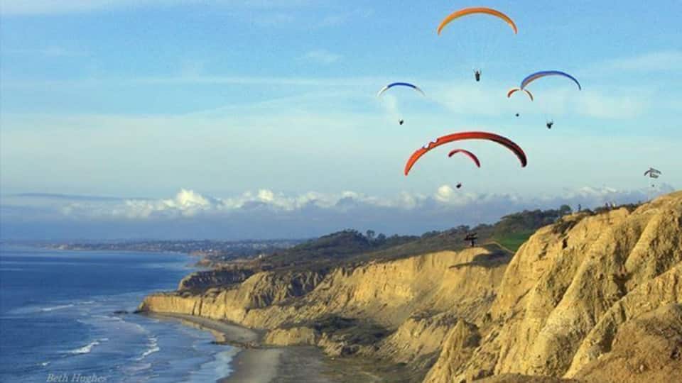 Paisagem costeira com falésias e uma praia.