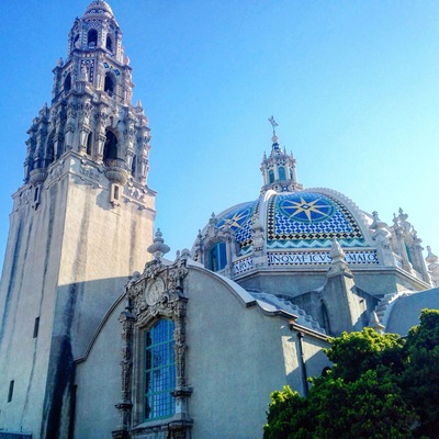Una catedral histórica con arquitectura elaborada, una imponente torre de campanas y una estructura de cúpula azul.