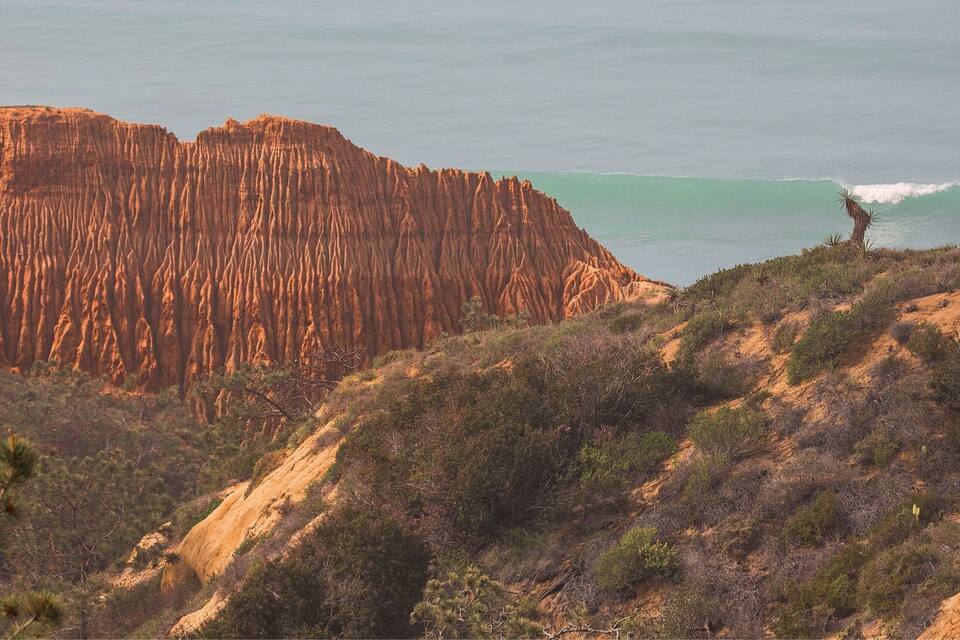 Un paisaje costero con un acantilado destacado y olas del océano.