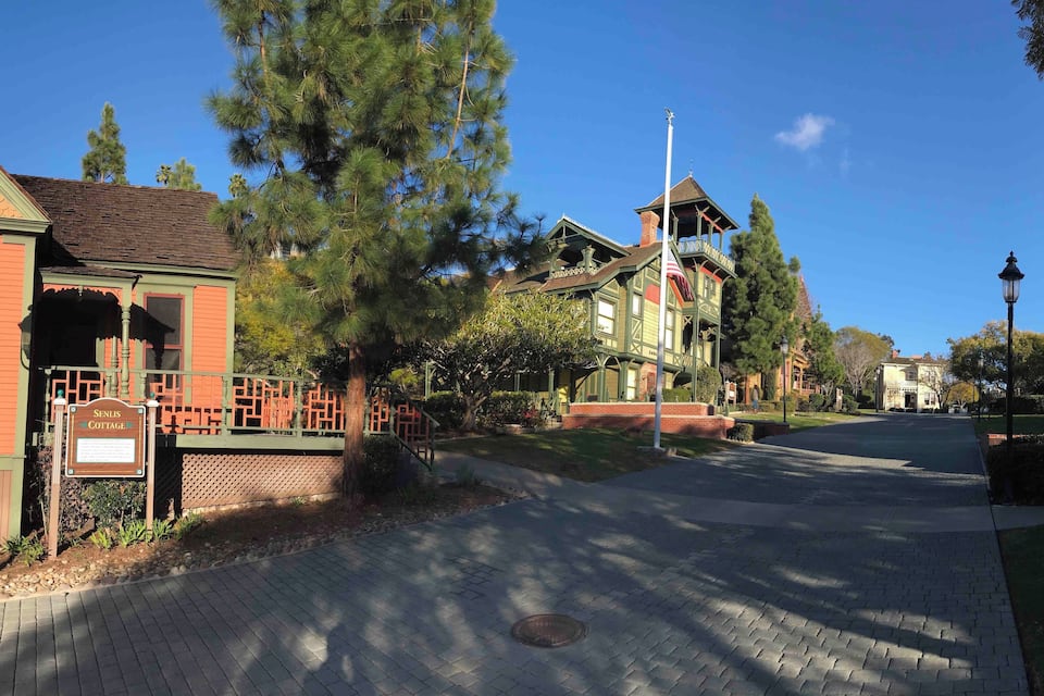 A historic street with a sign for 'Senius Cottage' and a flagpole.