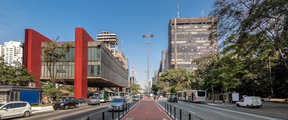 A city street with a bike lane, tall buildings, and a clear blue sky.