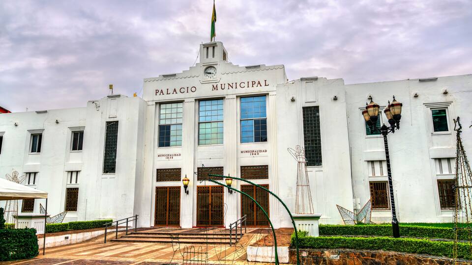 A white building with the sign "Palacio Municipal" and a clock tower.