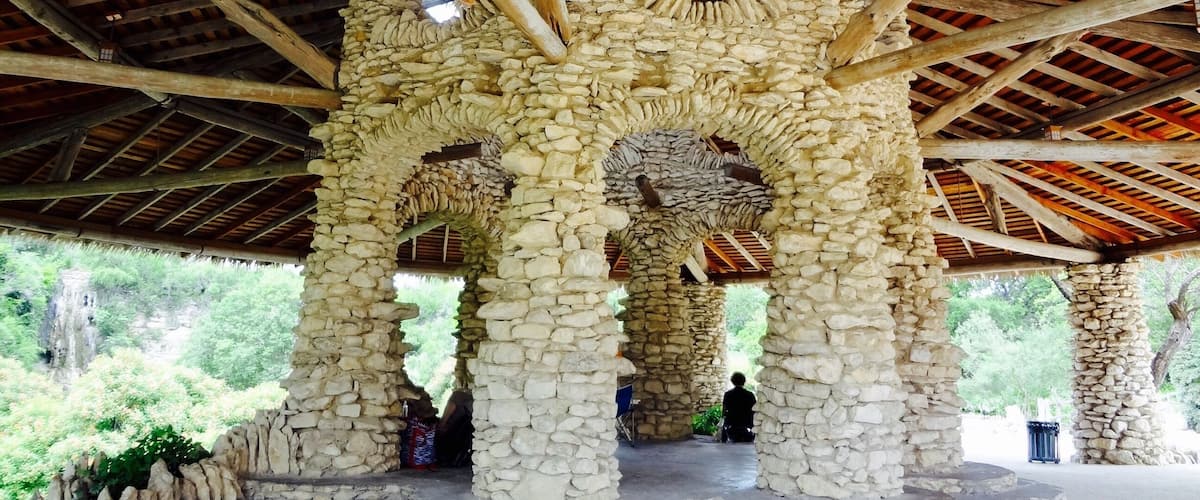 A stone structure with wooden beams and a stone roof.
