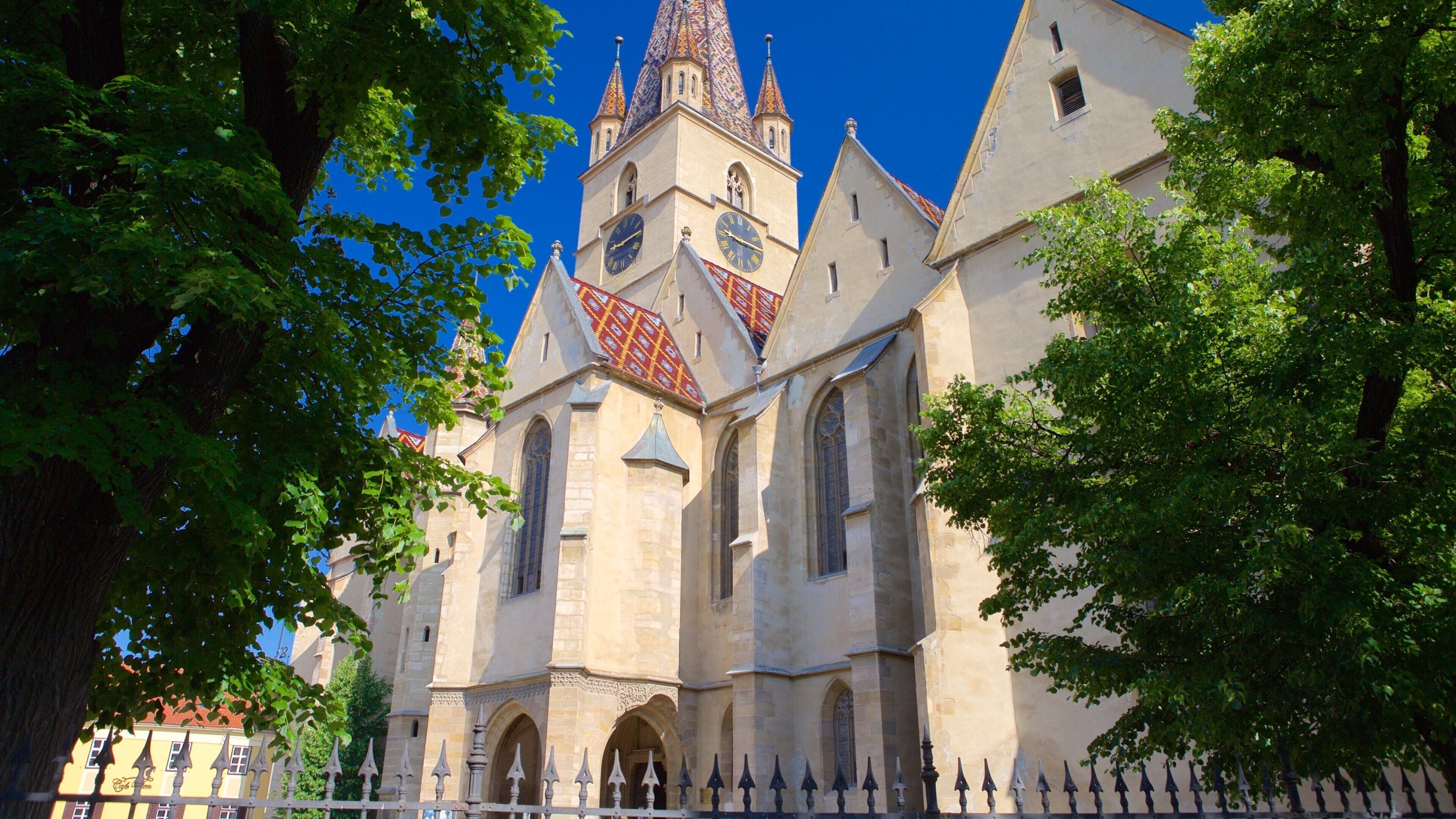 A historic church with a tall spire, arched windows, and a red-tiled roof.