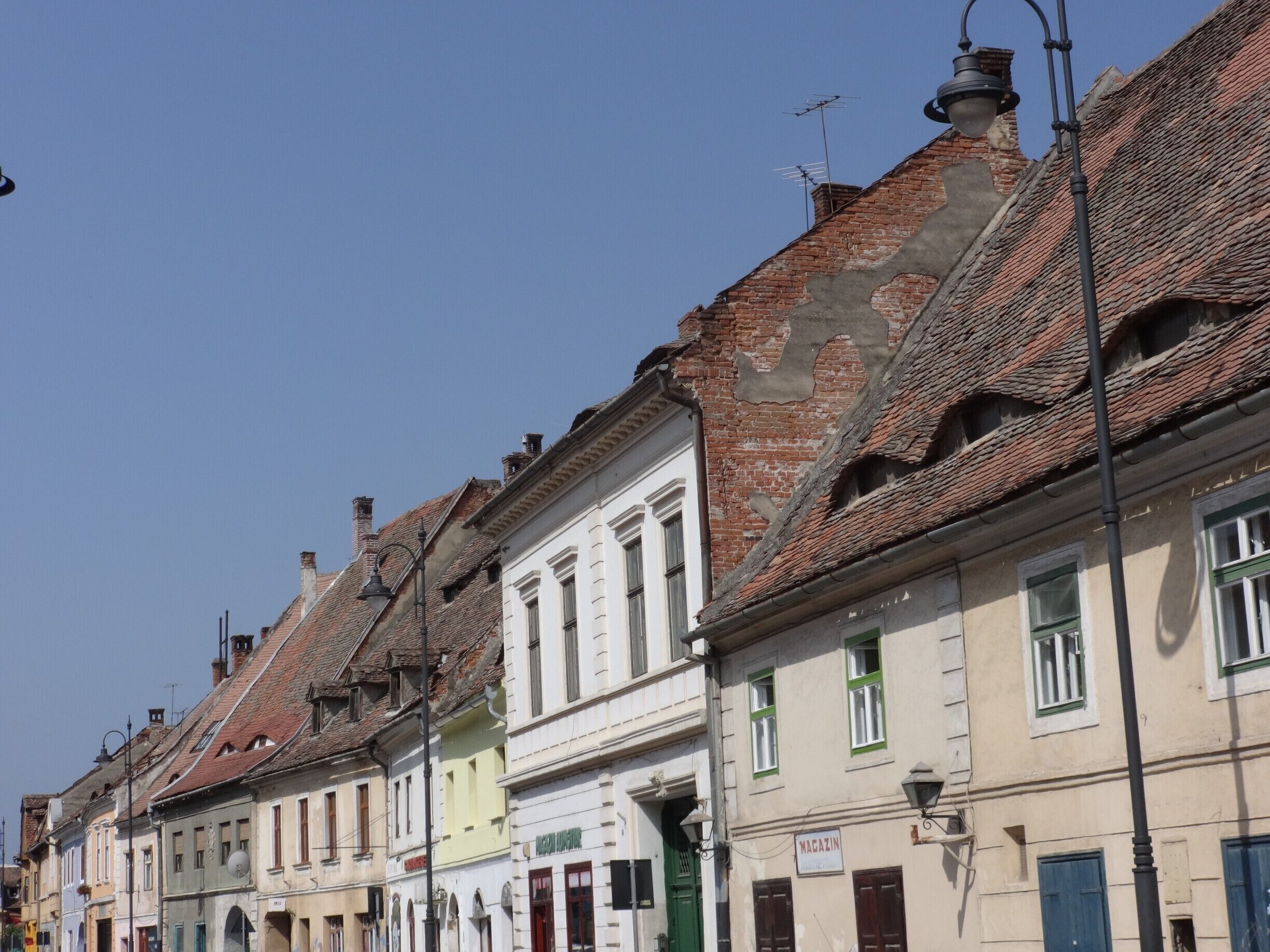The city of Sibiu and its surroundings are one of the most visited areas in Romania. It holds one of the best preserved historical sites in the country, many of its medieval fortifications having been kept in excellent state. Its old center has begun the process for becoming a UNESCO World Heritage Site in 2004. Sibiu and its surrounding area have many significant museums, with 12 institutions housing art collections, paintings, and exhibits in decorative arts, archeology, anthropology, history, industrial archeology and history of technology and natural sciences.
The Lower Town comprises the area between the river and the hill, and it developed around the earliest fortifications. The streets are long and quite wide for medieval city standards, with small city squares at places. The architecture is rather rustic: typically two-storey houses with tall roofs and gates opening passages to inner courts.