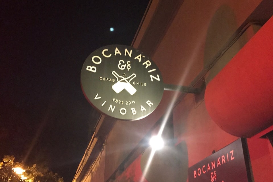 A nighttime street scene with a sign for 'Bocañariz Vinobar' and a map titled 'Mapa Viticola Bocañariz'.