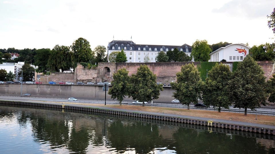 A river with a bridge, trees, and buildings in the background.