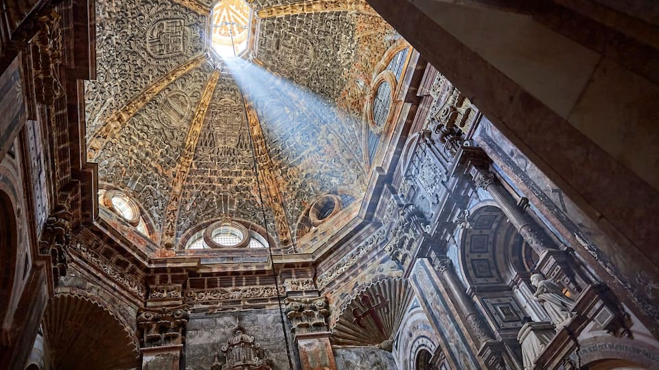 a ray of sunlight enters through the dome of the chapel of El Pilar in the cathedral of Santiago de Compostela