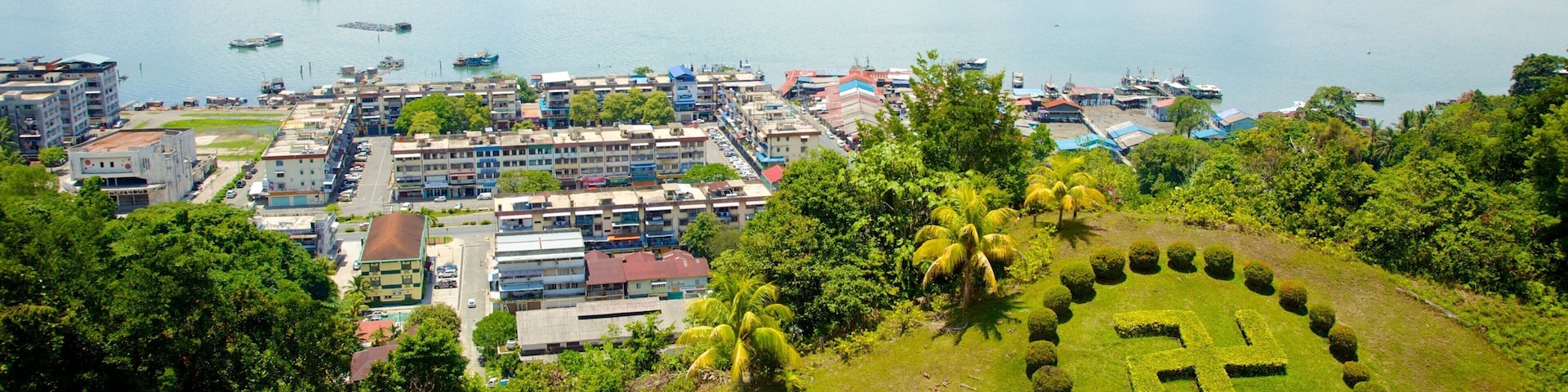 A coastal city with a marina, buildings, and a well-maintained park.