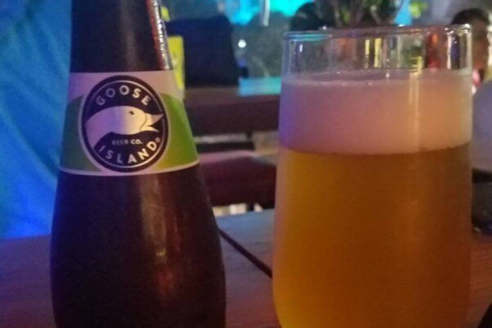 Een fles Sofie bier en een glas bier op een tafel.