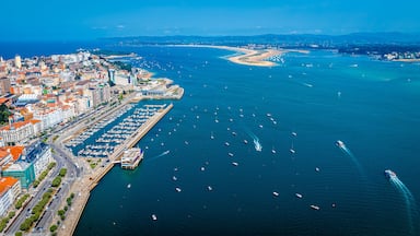 Uma cidade costeira com um porto, barcos e um mar azul cristalino.