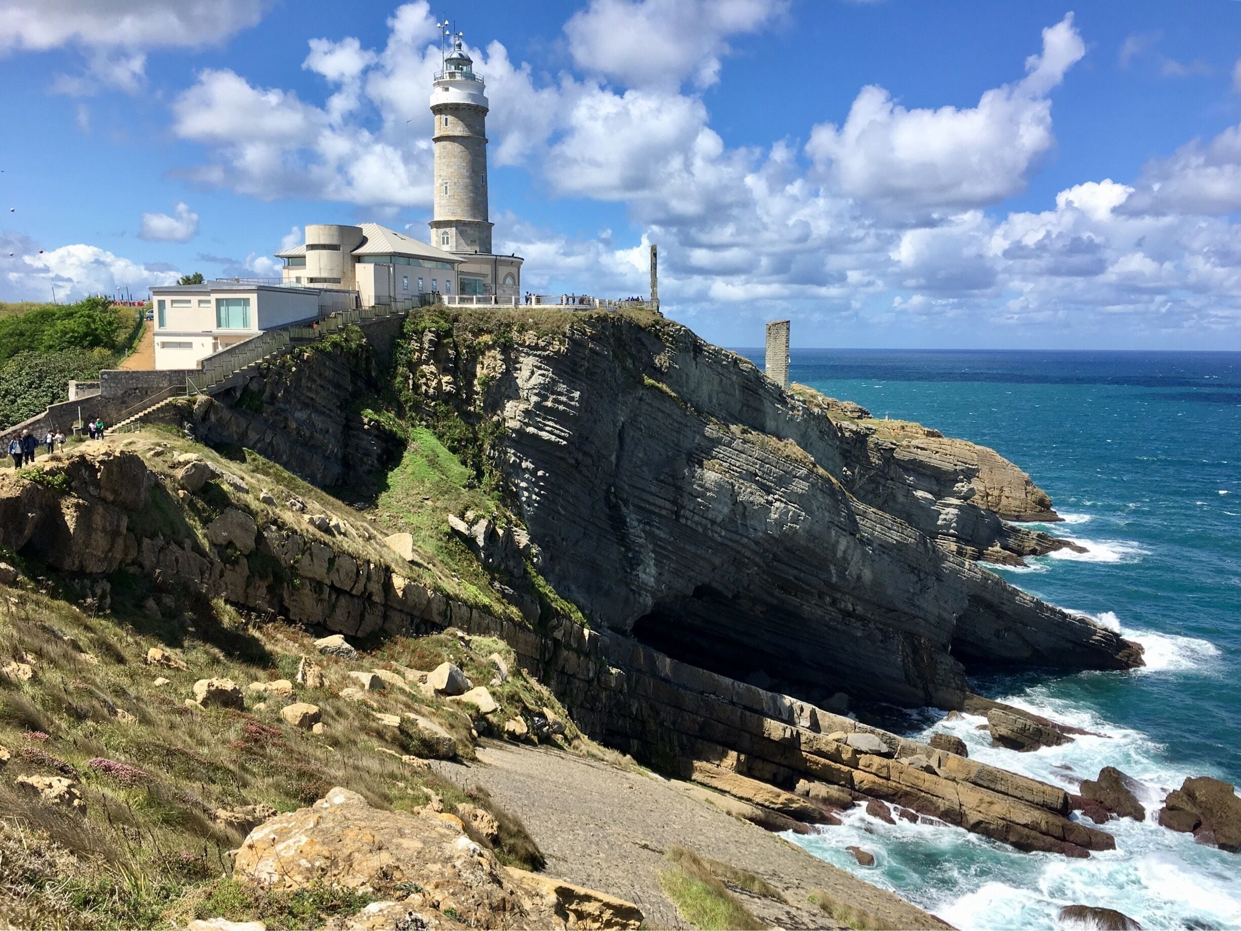 A coastal lighthouse on a rocky cliff, overlooking the ocean.