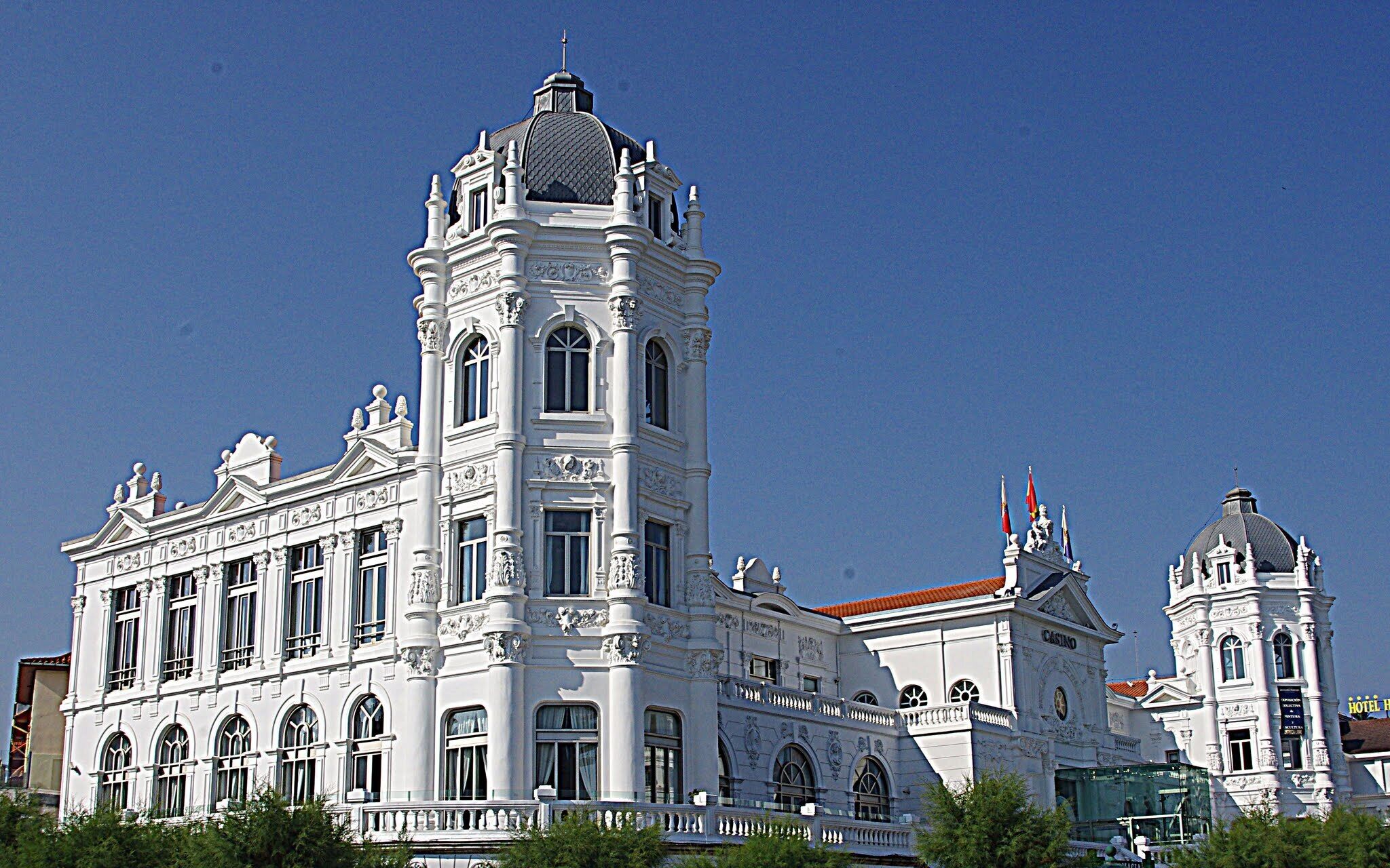 A large white building with ornate architectural details, including a prominent tower and a dome.