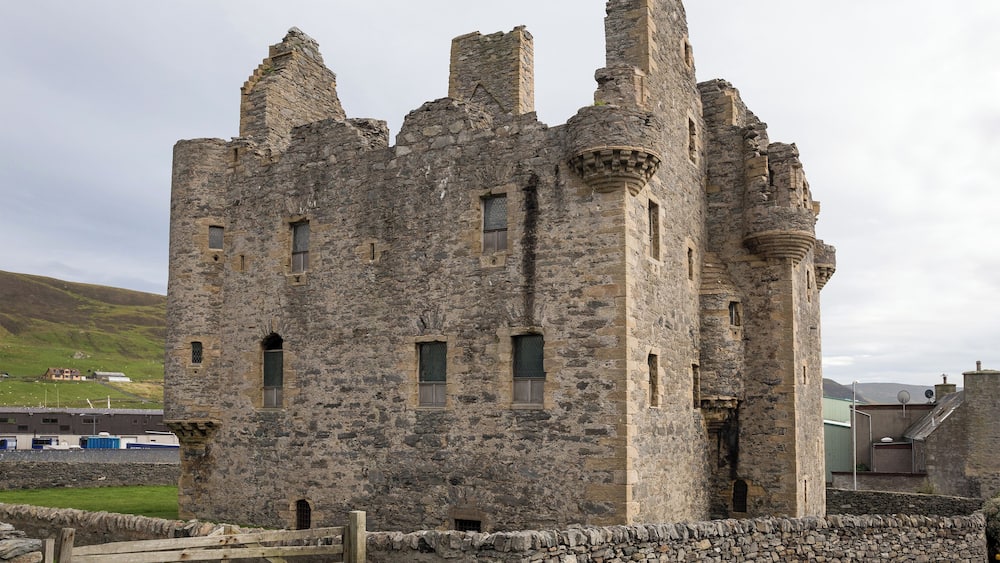 A historic stone castle with multiple towers and arched windows.