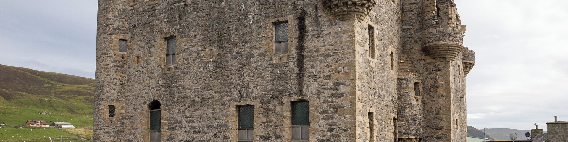 Un castillo de piedra histórico con múltiples torres y ventanas arqueadas.