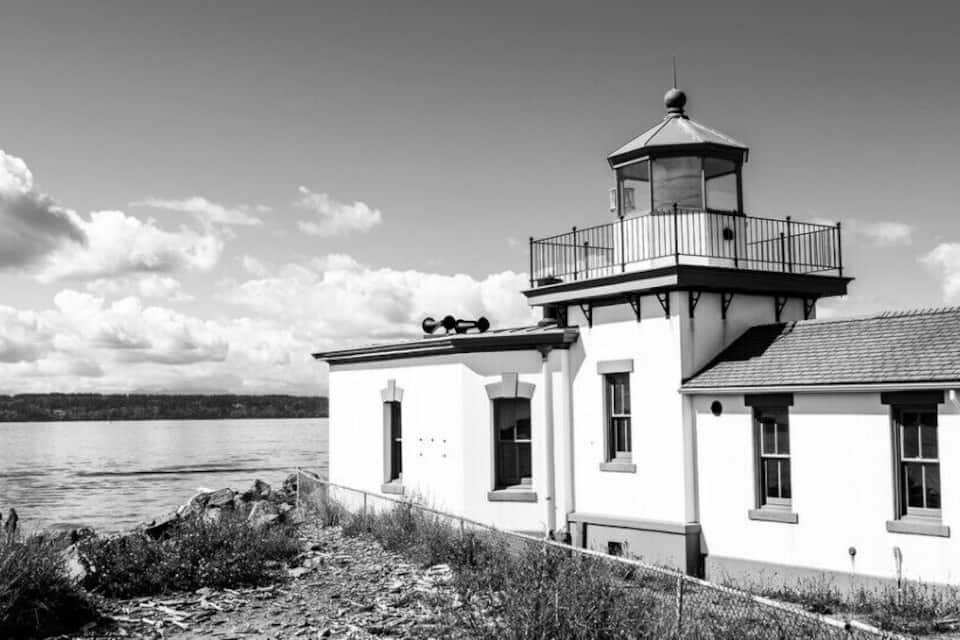 A lighthouse by the water with a clear sky.