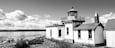 A lighthouse by the water with a clear sky.