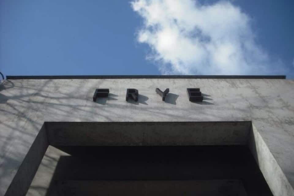 A concrete structure with the word "ERYE" inscribed on it against a clear blue sky with clouds.
